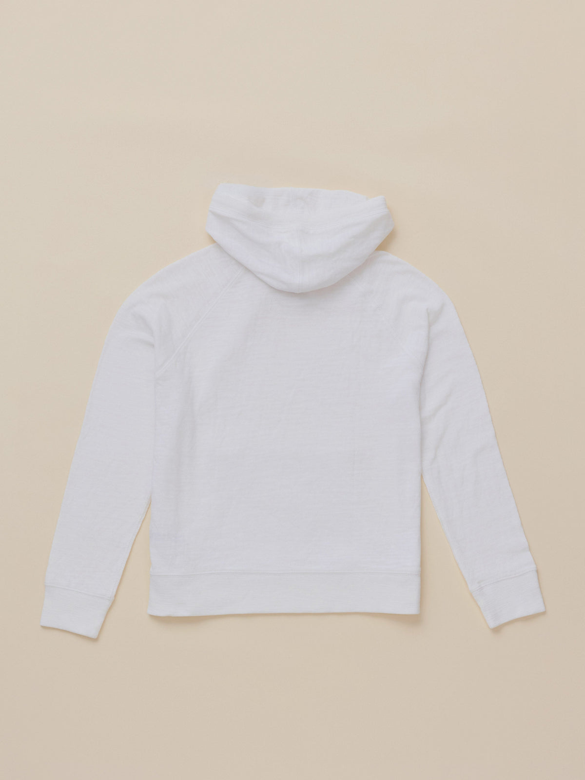A white long-sleeve hoodie shown from the back, laid flat on a solid beige background.